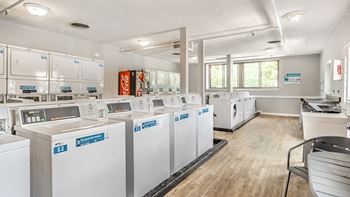 A laundromat with washers and dryers labeled E12